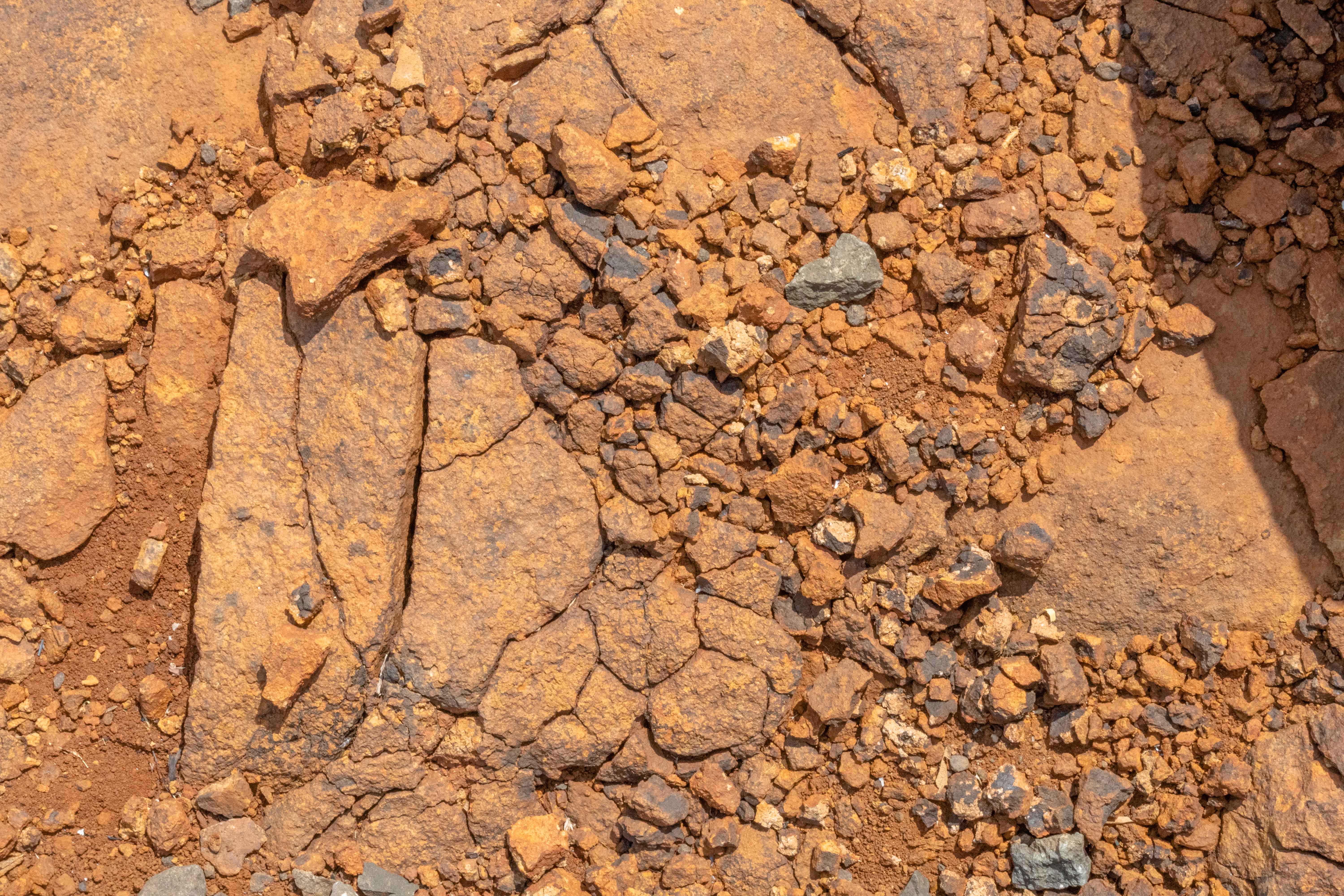 Weathered Lateritic Rocky Ground with Fractured Bedrock and Iron-Rich Soil