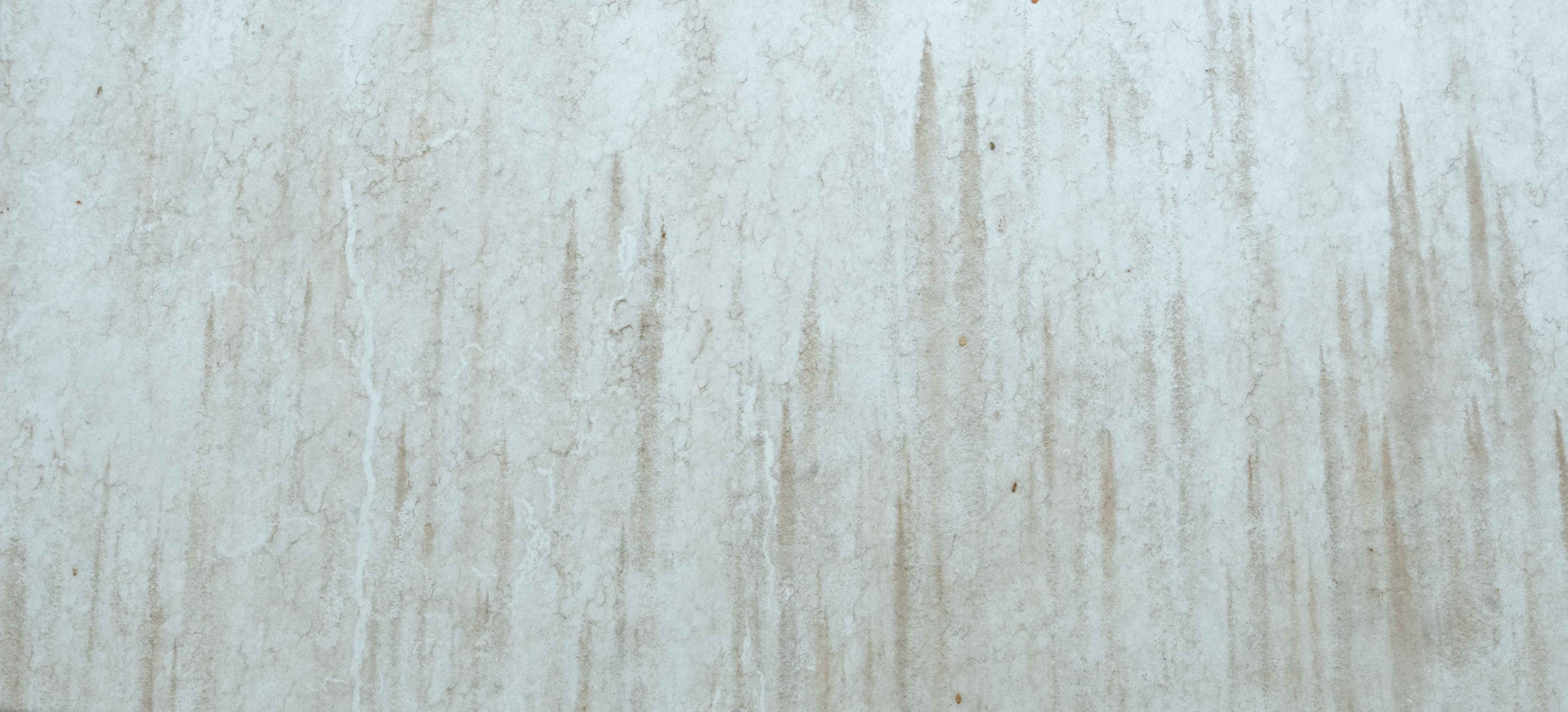 Weathered White Plaster Wall with Subtle Water Stains and Minimal Texture